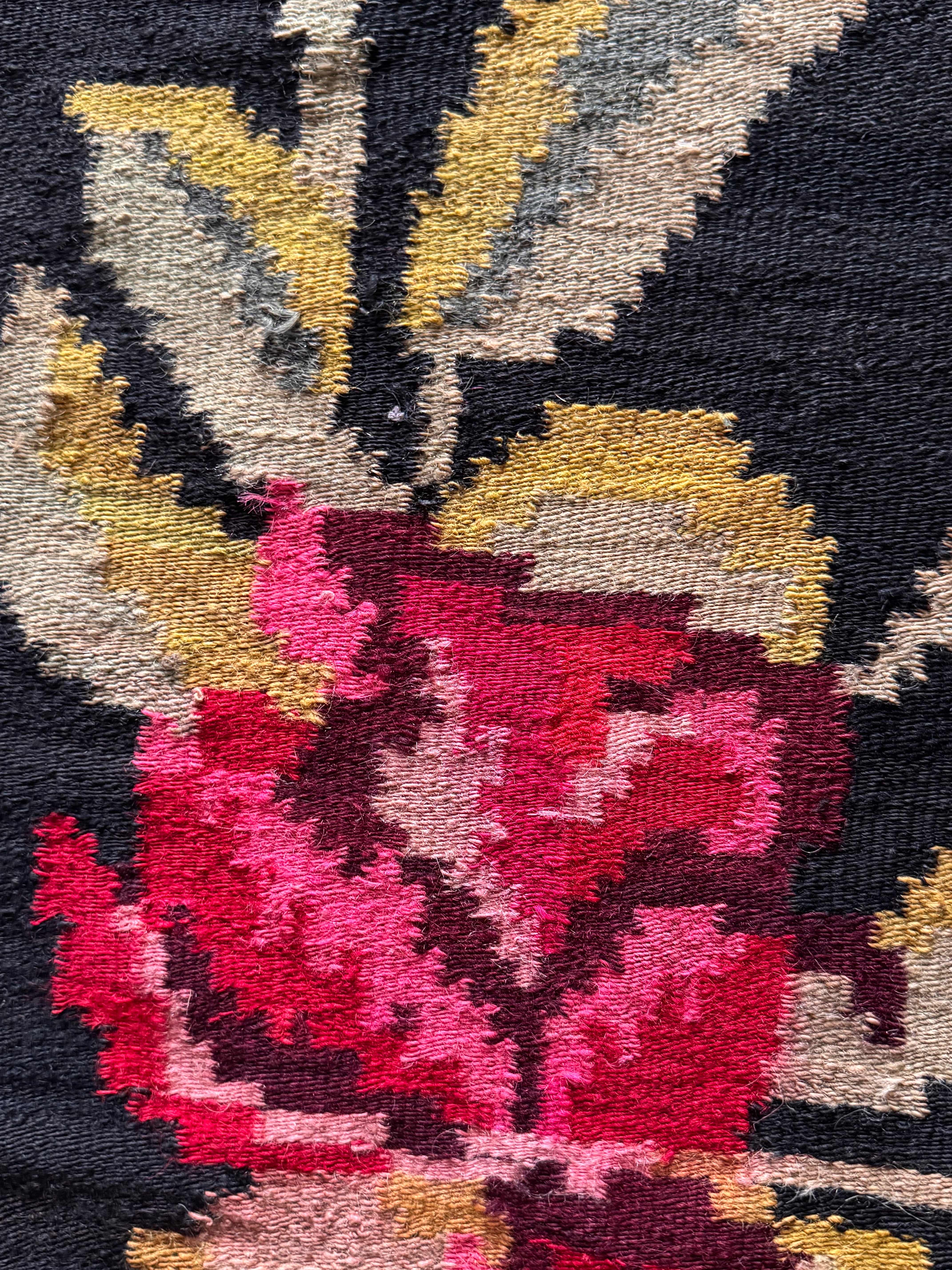 Romanian heritage rug featuring traditional flowers against a black background