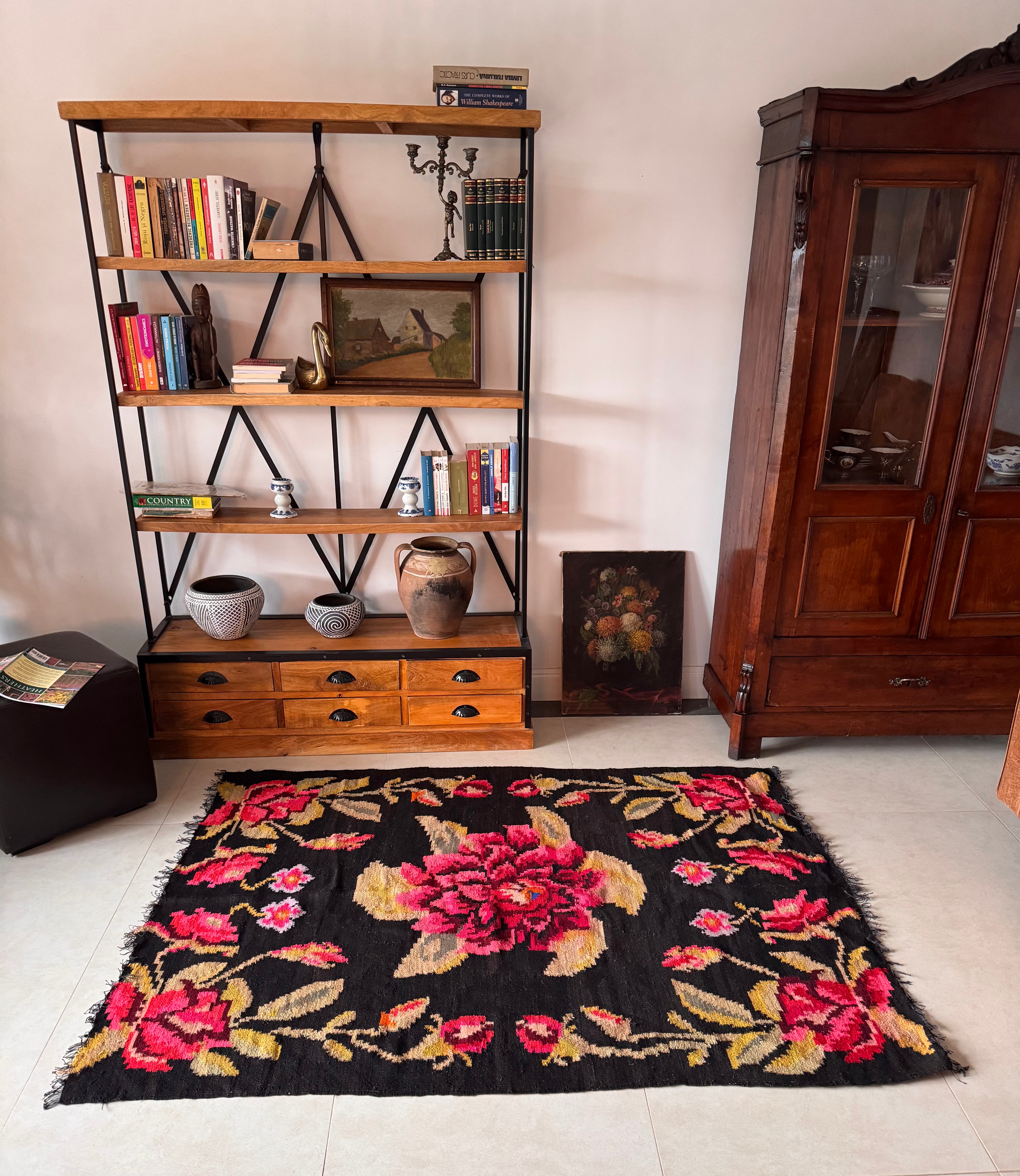 Floral design in pink, red and golden yellow on a black Romanian rug